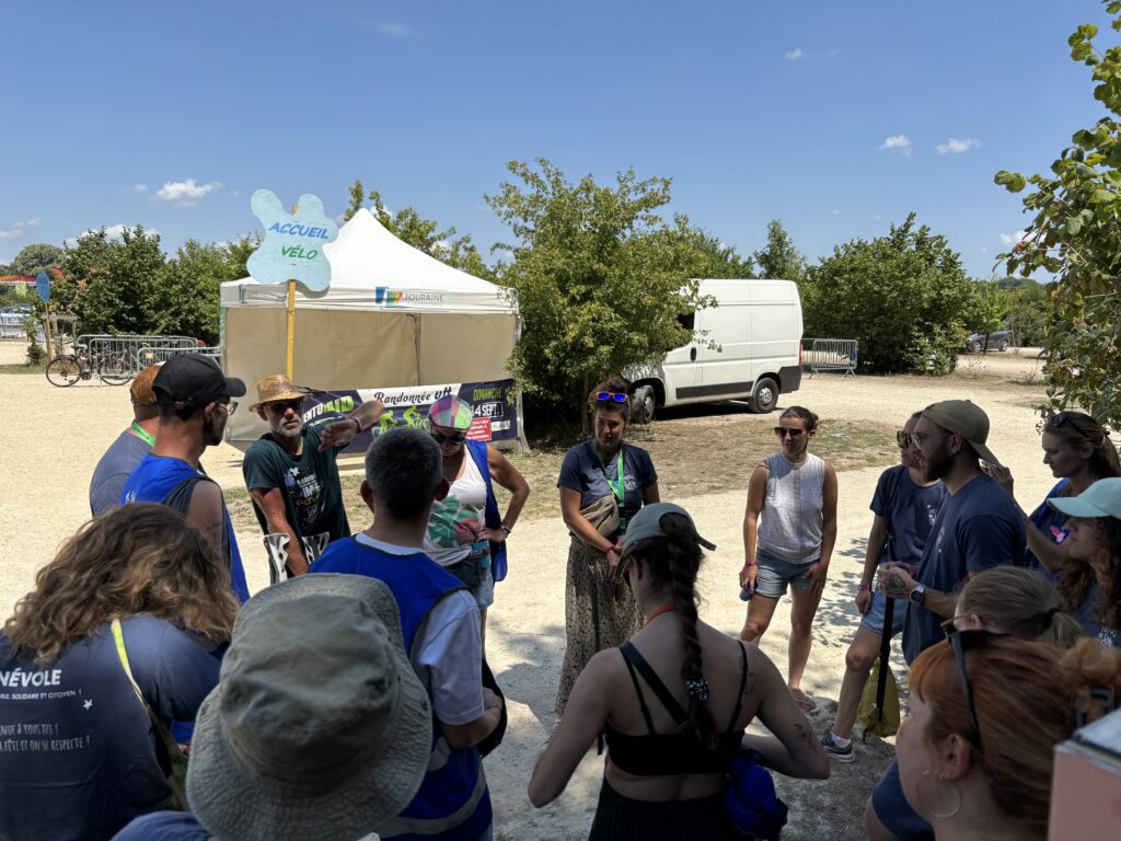 Briefing d'équipe de bénévoles devant le point d'accueil vélo lors d'un événement accompagné par Cap Access